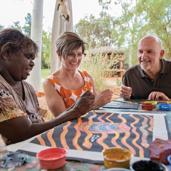 Making indigenous art; three people making Australian indigenous art by hand