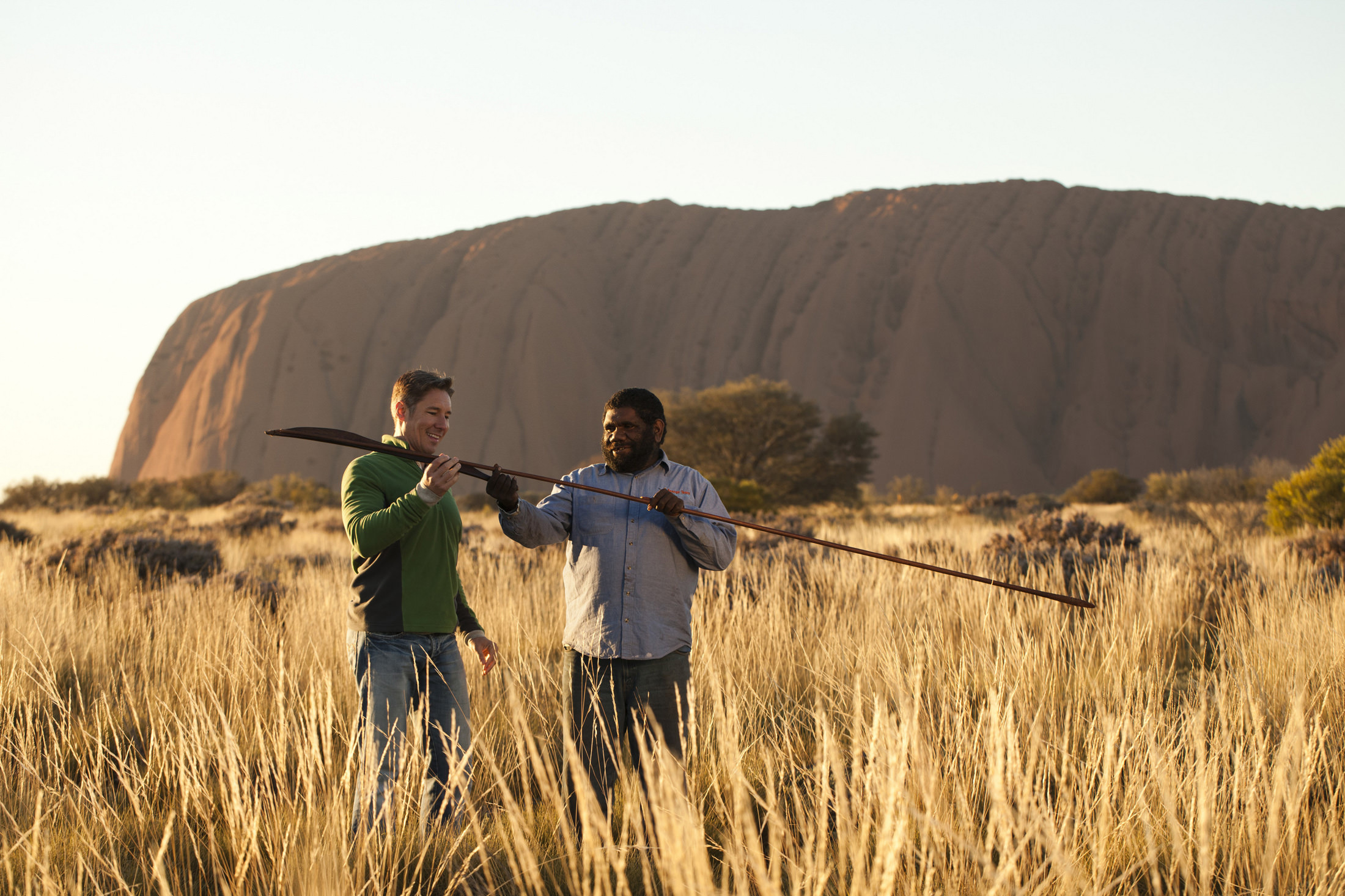 A man and a guide looking at a spear