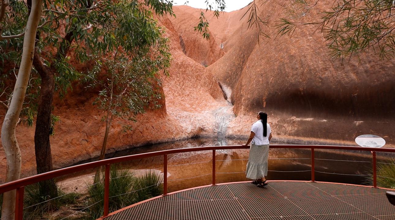 Woman standing and looking at Uluru